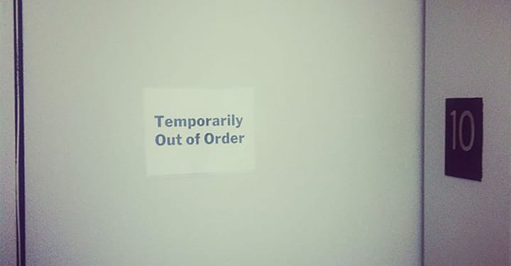 A photo of a while elevator at MoMA, a paper sign is posted: Temporarily Out of Order.