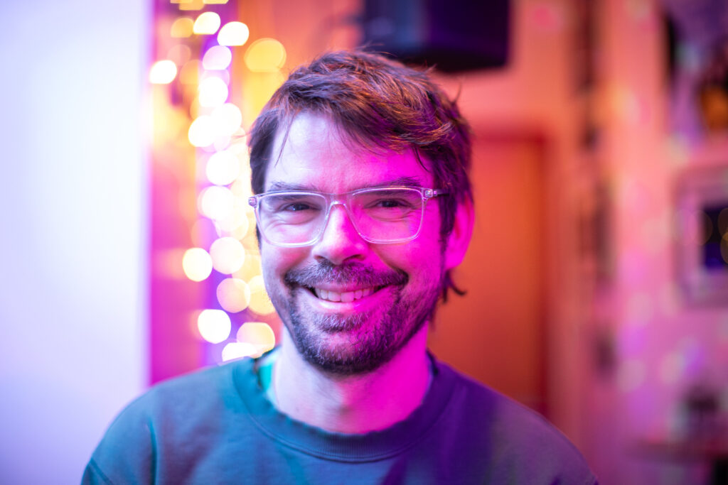 A smiling white guy wearing glasses.